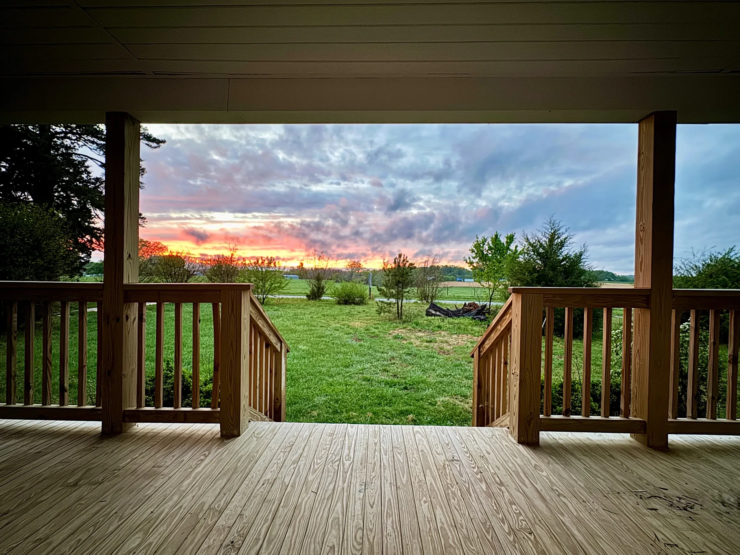 Covered porch with sunset view over rural farmland
